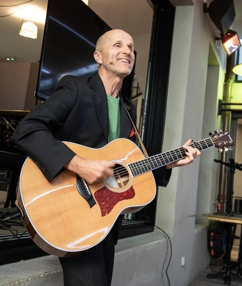 Thierry Claudon et sa guitare lors d'une conférence Joyeux récital pour libérer le mental